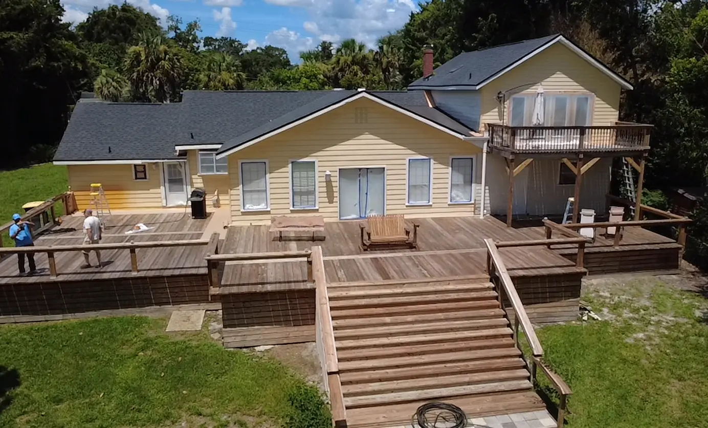Home exterior freshly painted in cream with a wood deck and stairs, Florida