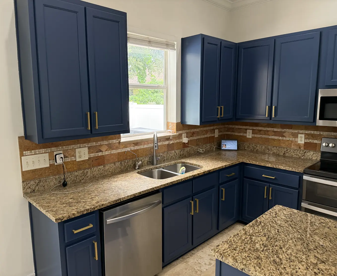 Kitchen with freshly painted navy blue cabinets and granite countertops, Florida