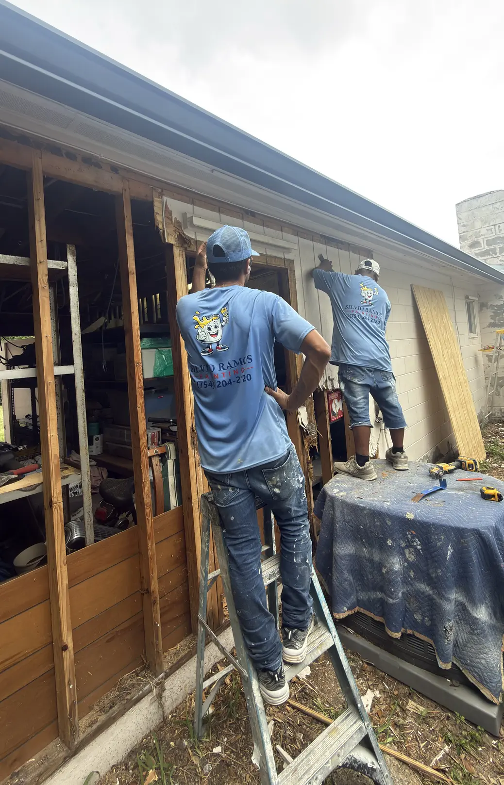 Silvio Ramos Painting crew painting a home exterior with floor protection in place, Florida