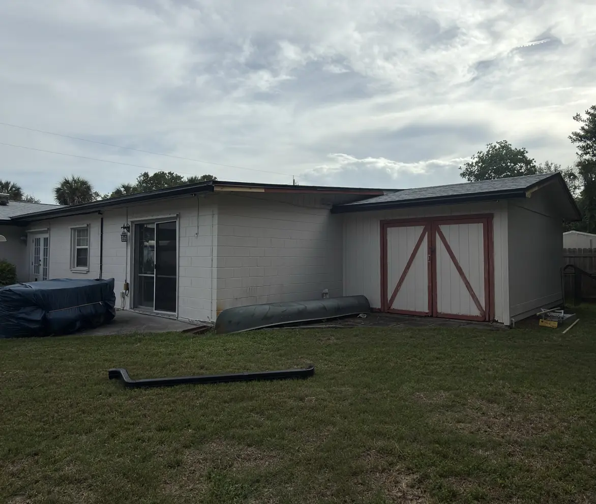 Single-story home exterior freshly painted in soft green with a garden gate, Florida