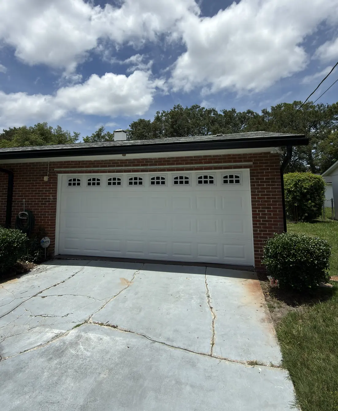 Brick home with a freshly painted white garage door and trim, Florida