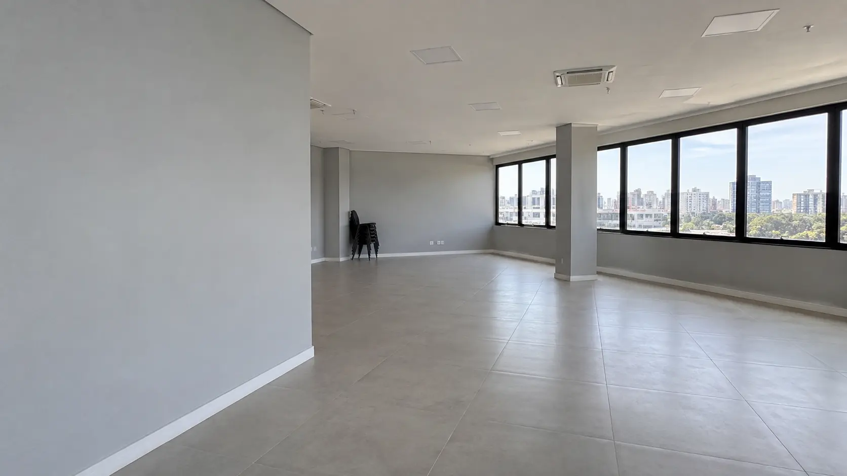 Empty open-plan commercial interior with freshly painted light walls and large windows